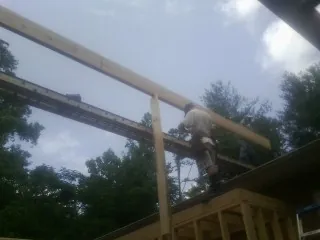 Carpenter setting a ridge beam over a new addition frame — Ice Dam Removal by Roofing Brothers in Goodfield