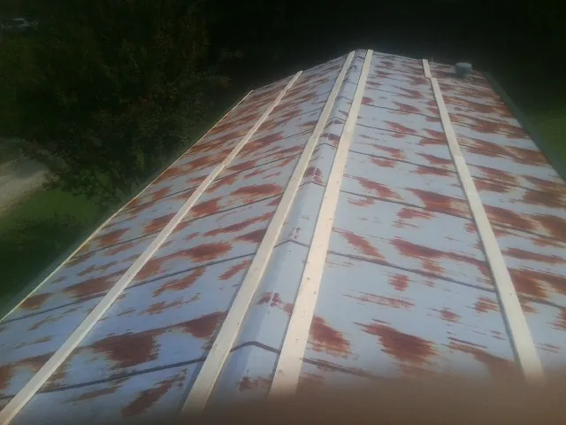 Rusted metal roof panels with new wood purlins before replacement — Storm Damage Roof Repair in Goodfield by Roofing Brothers