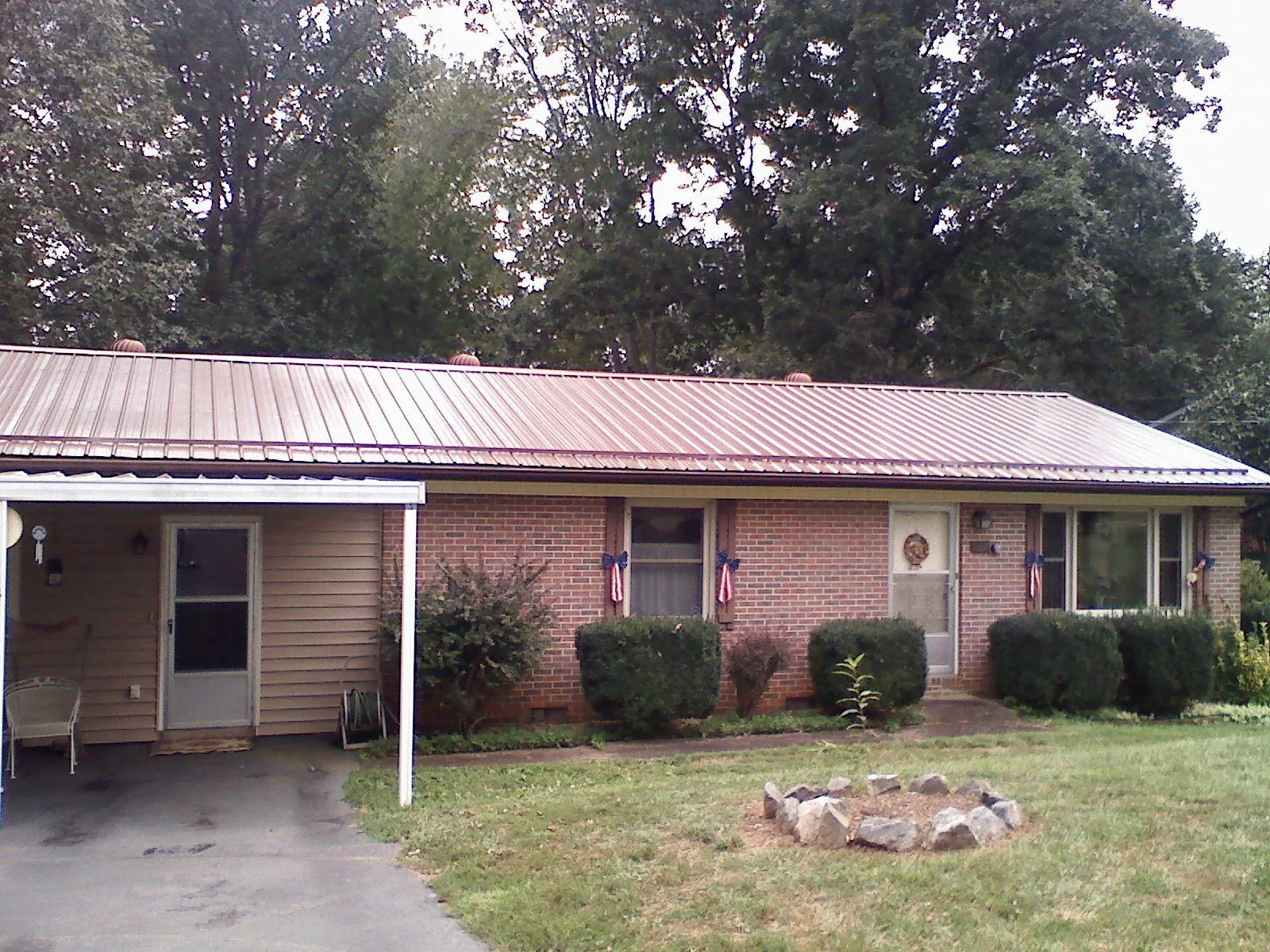 Bronze metal roof and carport on a brick ranch home — Roof Repair work by our crew in Goodfield